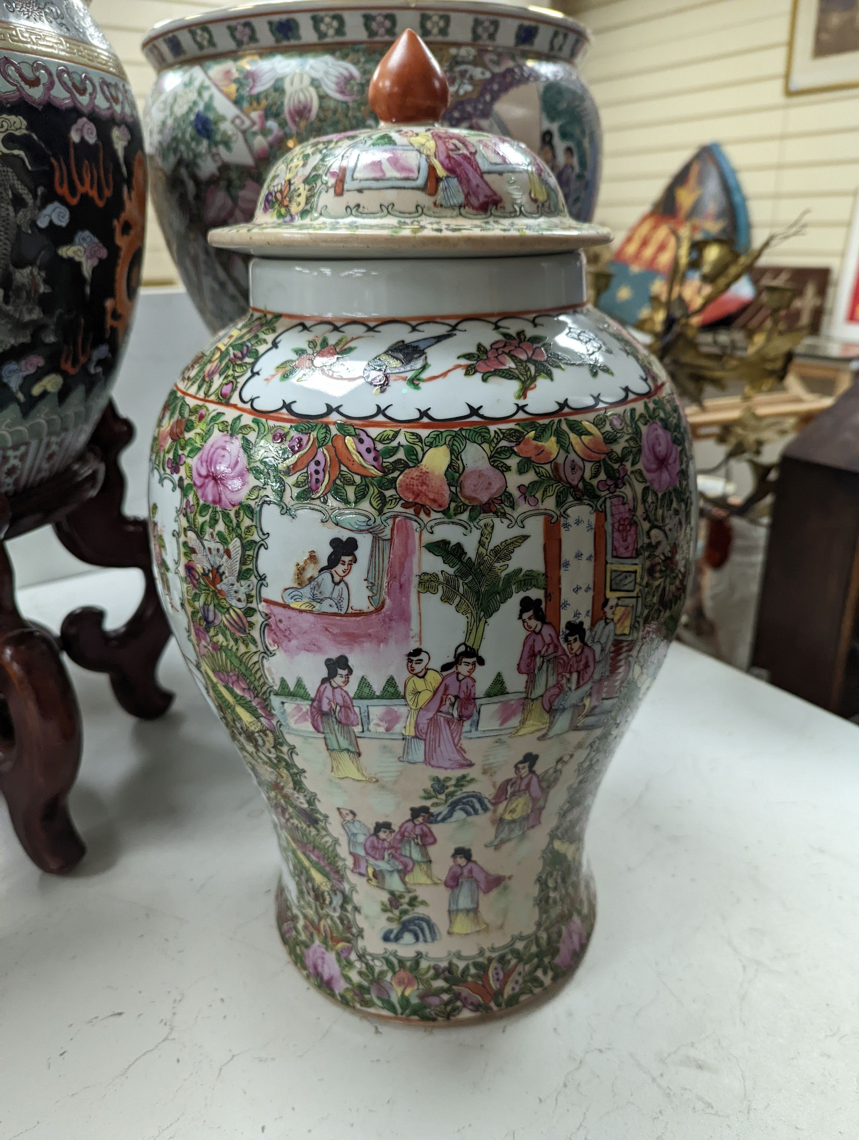 A pair of Chinese fish bowls on hardwood stands and a similar jar and cover, Fish bowls and stands 54 cms high.